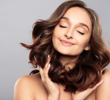 Brunette girl with healthy curly hair and natural make up . Beau