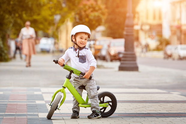 Happy boy in white helmet ride his first bike