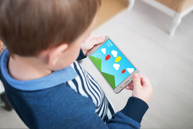 Boy play game on smart phone. Creative applications for children stimulate thinking.