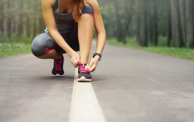 young sporty woman preparing to run in early foggy morning in th