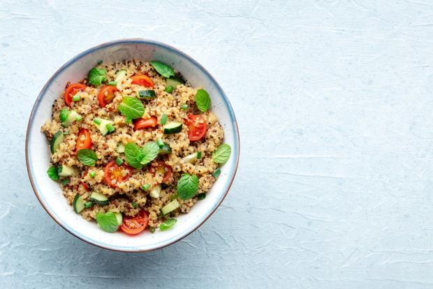 Quinoa tabbouleh salad in a bowl, a healthy dinner with tomatoes and mint