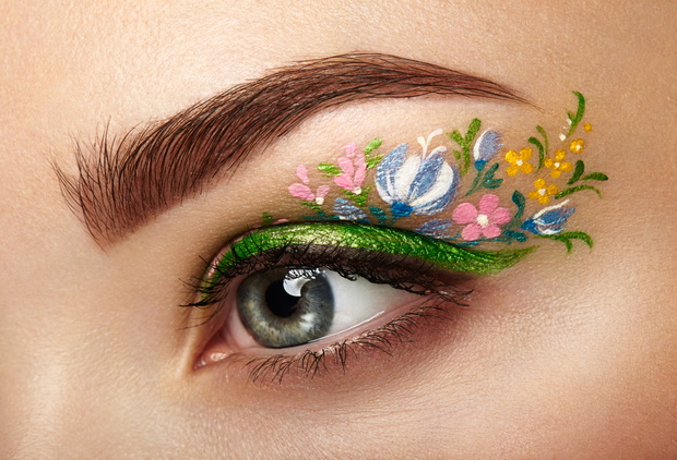 Eye makeup girl with a flowers. Spring makeup. Beauty fashion. Eyelashes. Cosmetic Eyeshadow. Make-up detail. Creative woman holiday make-up
