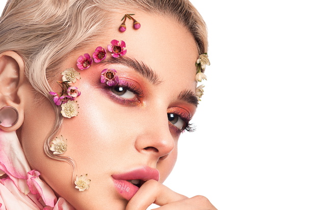 Portrait of a beautiful elegant girl with make-up and flowers on her face and a cold wave retro. Beauty, health, youth and spring concept