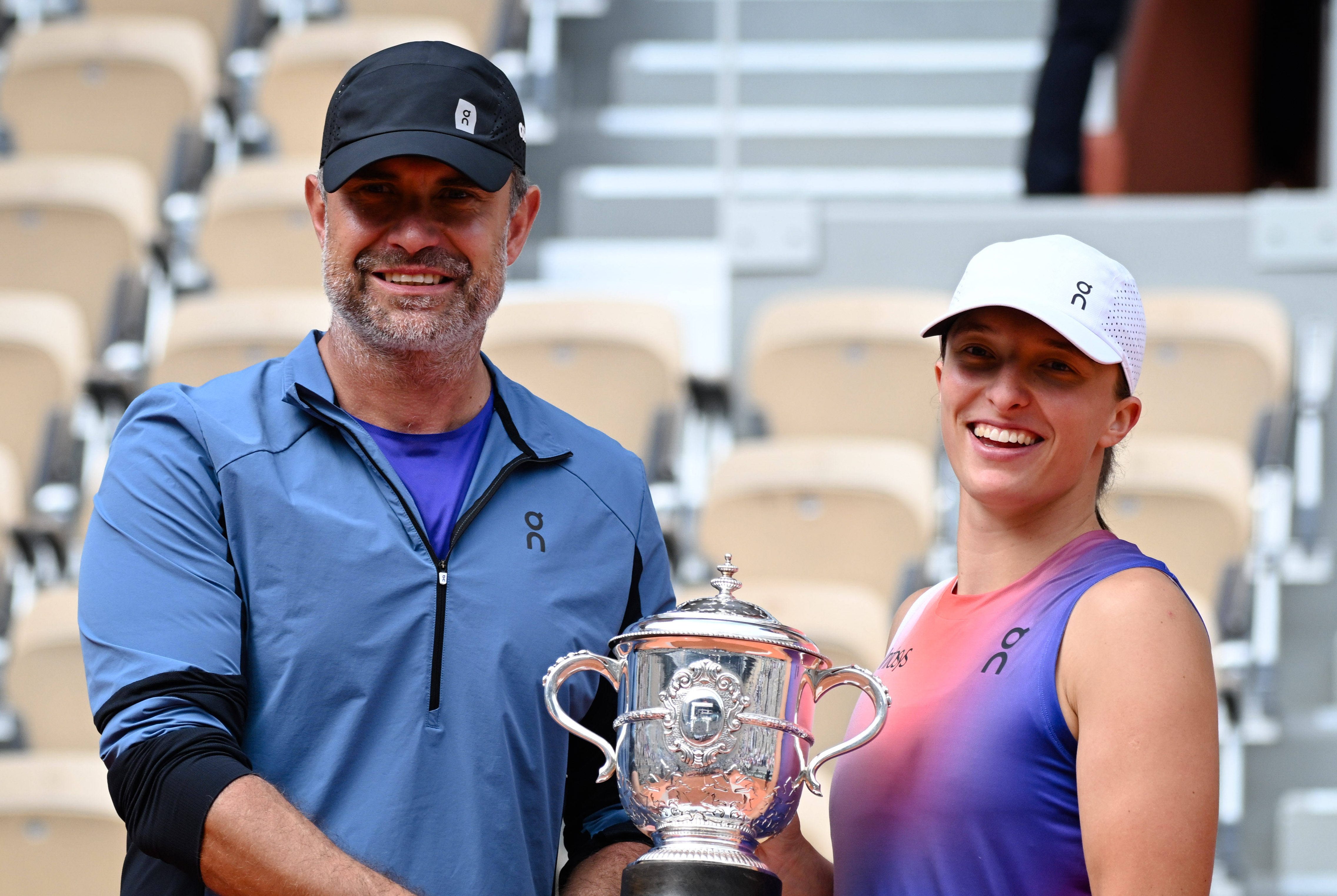 Iga Swiatek ( POL ) and Tomasz Wiktorowski ( coach ) celebrate with the trophy during the 2024 French Open at Roland Gar