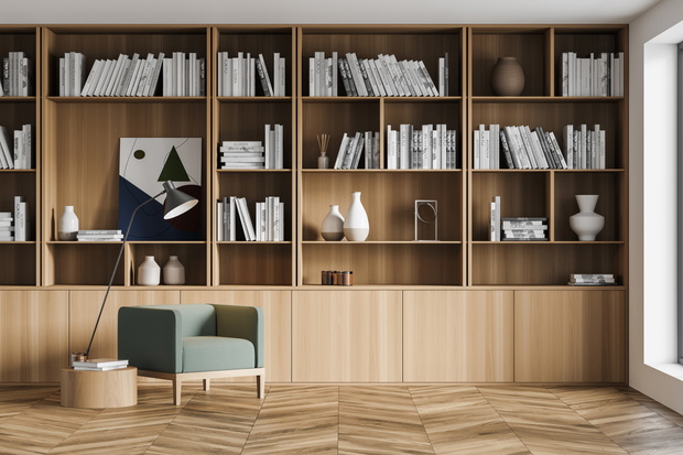 Stylish modern interior of contemporary library with comfortable armchair. Book with bookshelf. Wooden parquet floor.