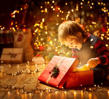 Christmas Child Open Present Gift, Happy Baby Boy looking to Mag