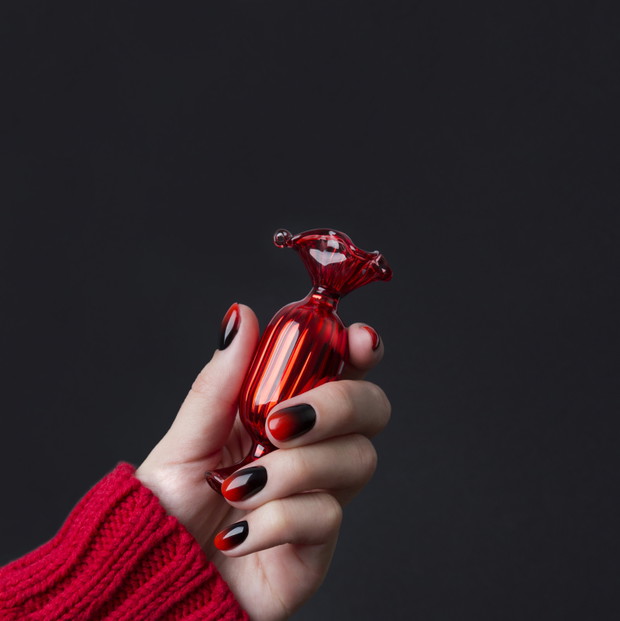 Female hand with red black ombre gradient nails in sweater