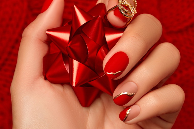 Womans hand with fashionable red manicure close up. Manicure, pedicure beauty salon concept.