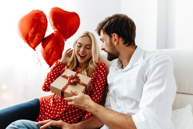 Couple. Love. Valentine's day. Emotions. Man is giving a gift bo