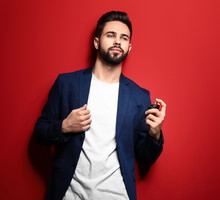 Handsome man with bottle of perfume on color background