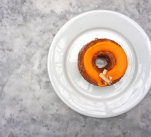 Close up Cronut (combination of croissant and doughnut) Topped with Passion fruit jam and toasted coconut Ganache