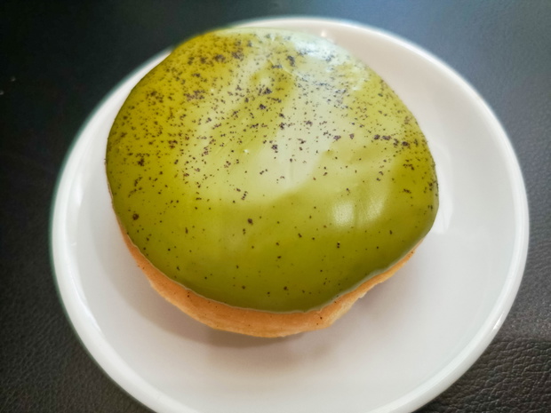 photo of green tea flavored donuts on a white plate with a black background
