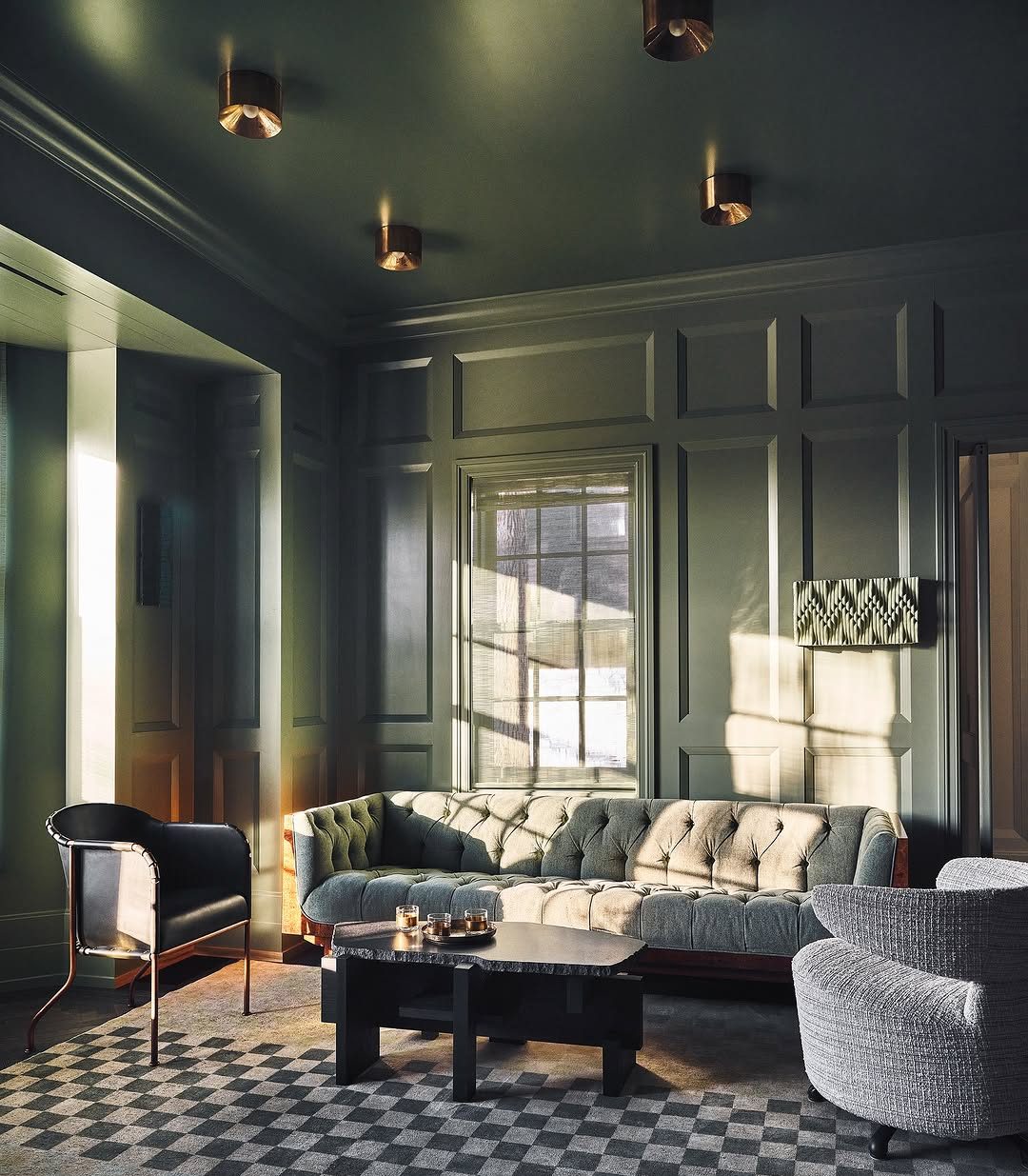 ON THE HOUSE For this private residence lounge, the dark green high-gloss paint by Farrow &amp; Ball sets a moody backdrop. A vintage Ilum Wikkelso loveseat adds character, facing a bespoke stone coffee table by Sung Jang. Erin Trefry’s artwo