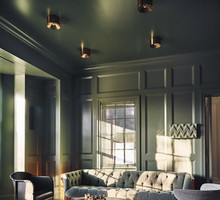 ON THE HOUSE For this private residence lounge, the dark green high-gloss paint by Farrow & Ball sets a moody backdrop. A vintage Ilum Wikkelso loveseat adds character, facing a bespoke stone coffee table by Sung Jang. Erin Trefry’s artwo