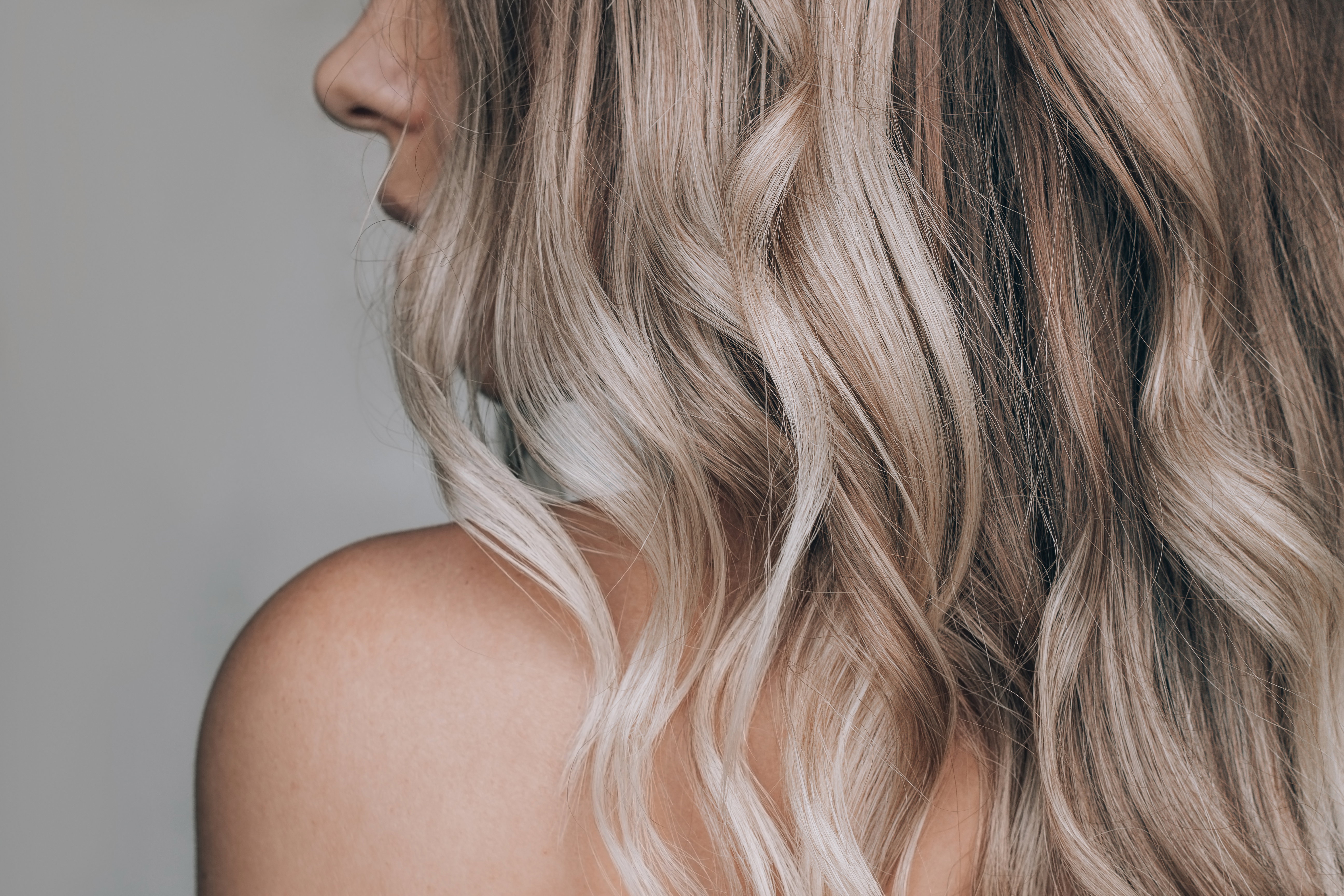 Close-up of the wavy blonde hair of a young blonde woman isolate