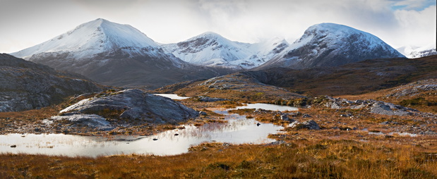 A cloud and snow capped summit of Beinn Eighe in the Scottish Highlands.