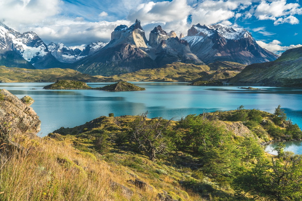 Blue lake on a snowy mountains background and cloudy sky Torres