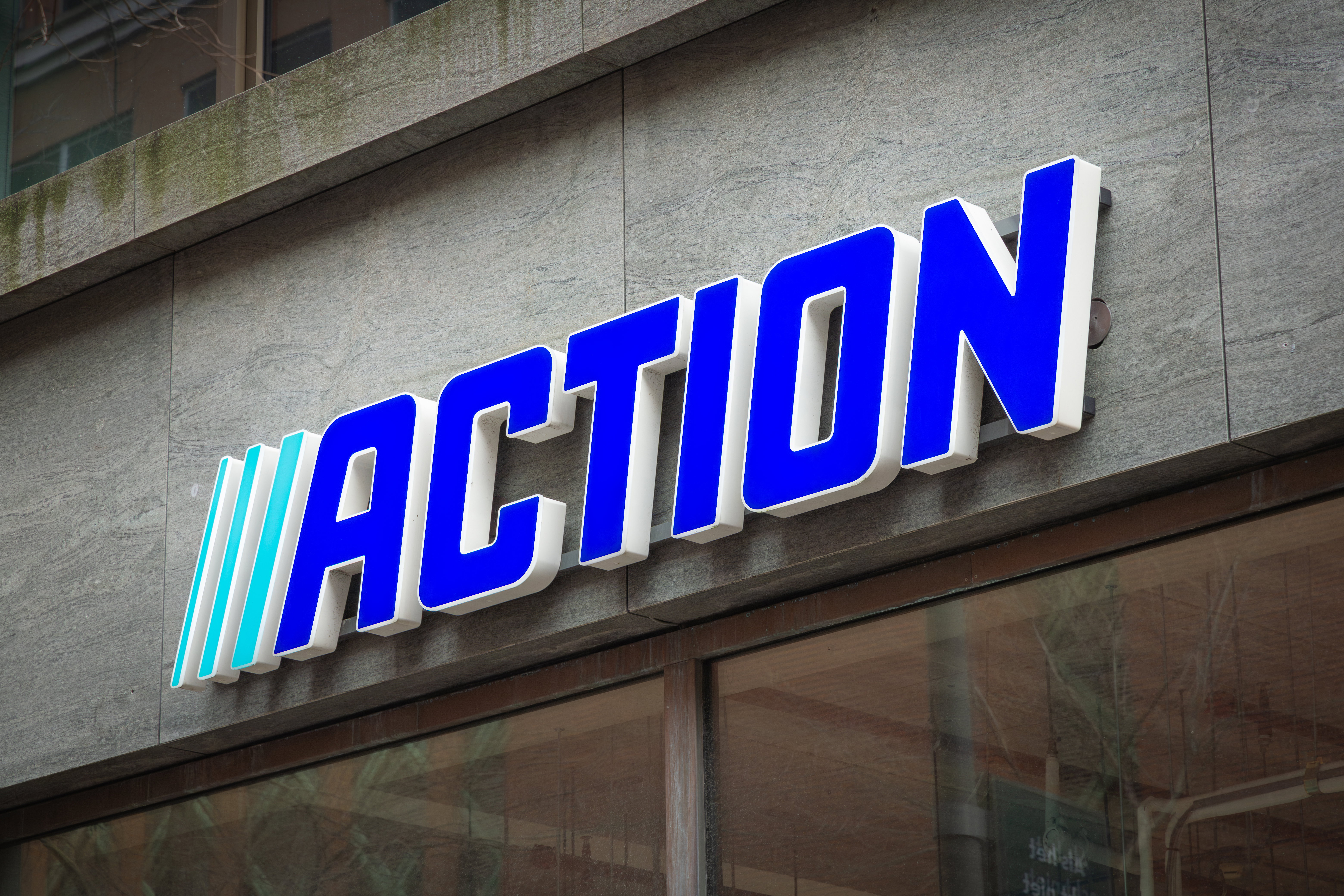 Action store with logo sign board hanging above entrance door. Action is fastest growing non-food discounter in Europe, Dutch international discount store. The Hague, the Netherlands. 15 February 2025