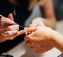 Woman in salon receiving manicure