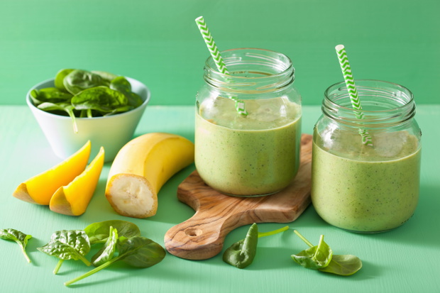 healthy green smoothie with spinach mango banana in glass jars