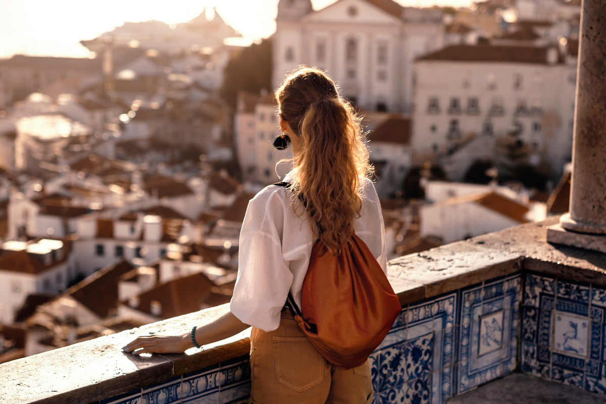 Female tourist looking at old town from balcony