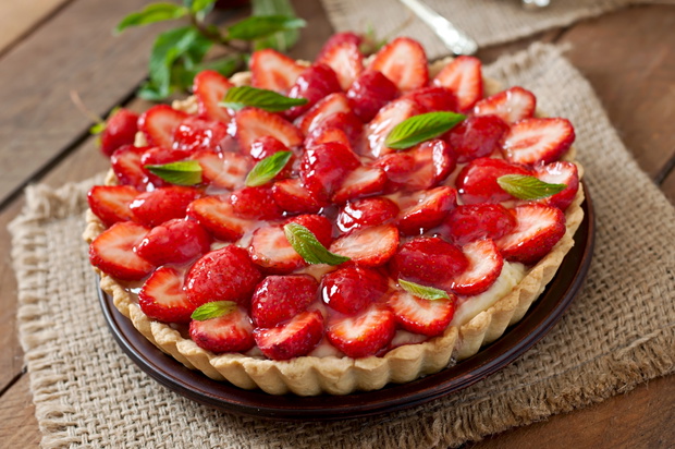 Tart with strawberries and whipped cream decorated with mint leaves