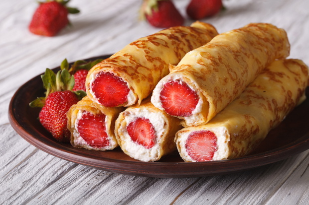 Crepes with fresh strawberries and cream cheese on a plate