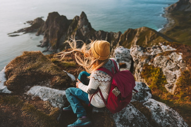 Woman relaxing alone travel in Norway adventure vacations healthy lifestyle backpacking Vesteralen landscape rocks and sea aerial view