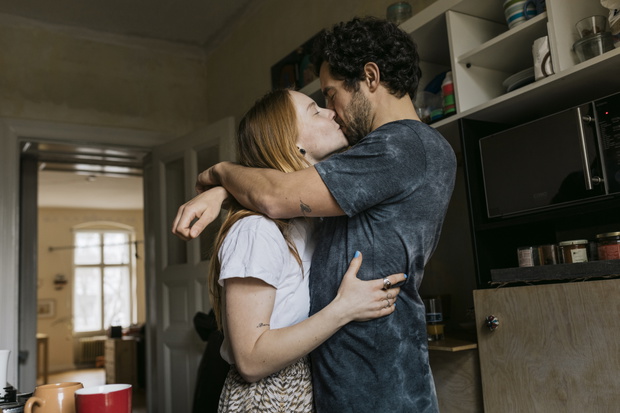 Man And Woman Kissing And Hugging In Living Room