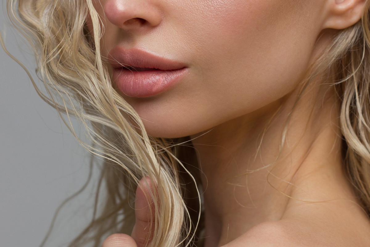 Close-up of woman's Lips with Fashion pink Make-up and Manicure on Nails. Beautiful female full lips with perfect Makeup. Part of female face. Macro shot of beautiful make up on full lips