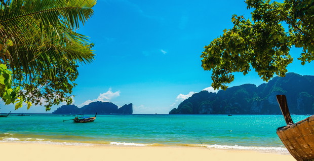 Wooden boat on the sandy shore of the exotic beach