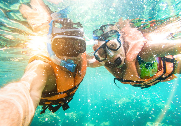 Senior happy couple taking selfie in tropical sea excursion with