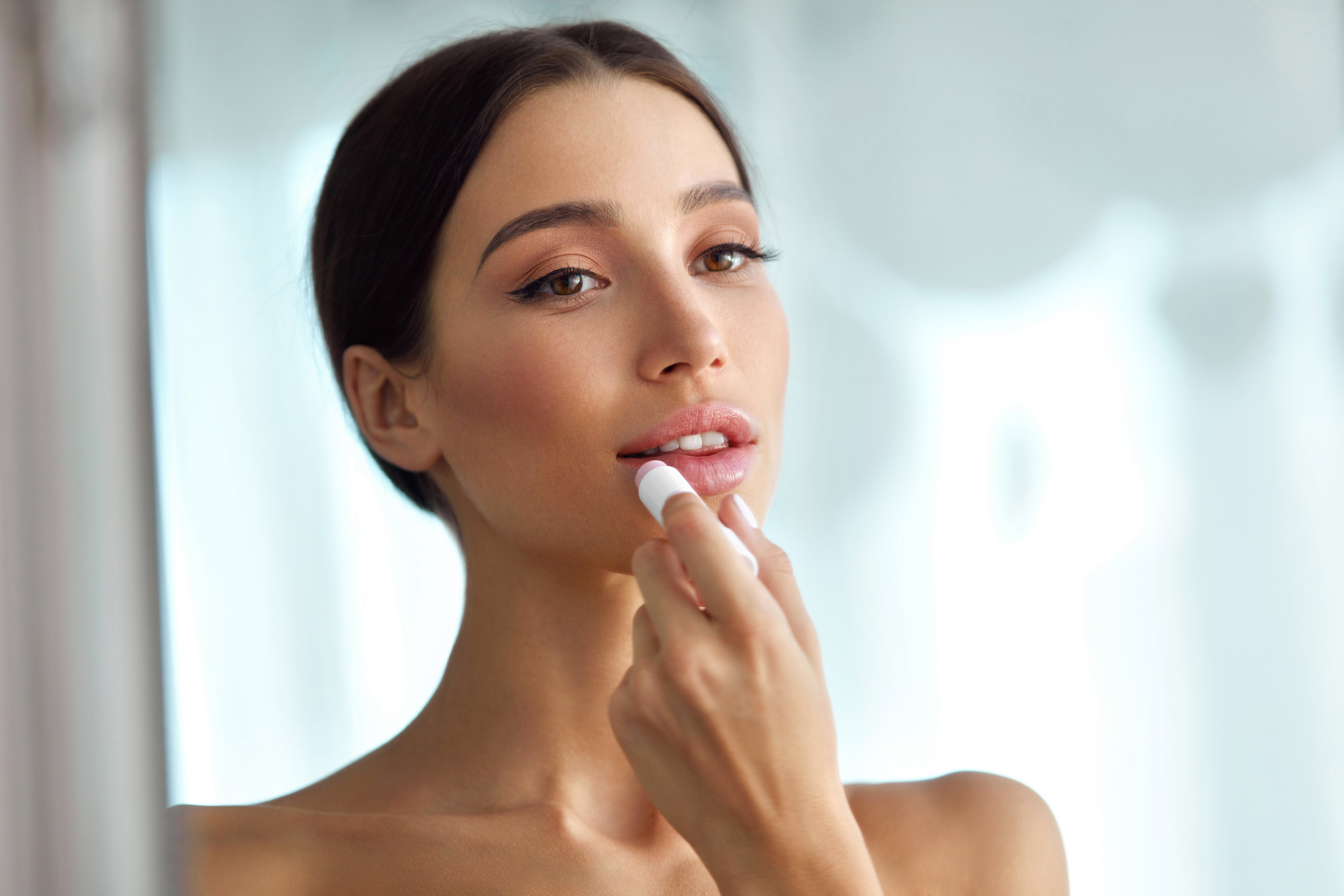 Beautiful Woman With Beauty Face Applies Balm On Lips. Skin Care