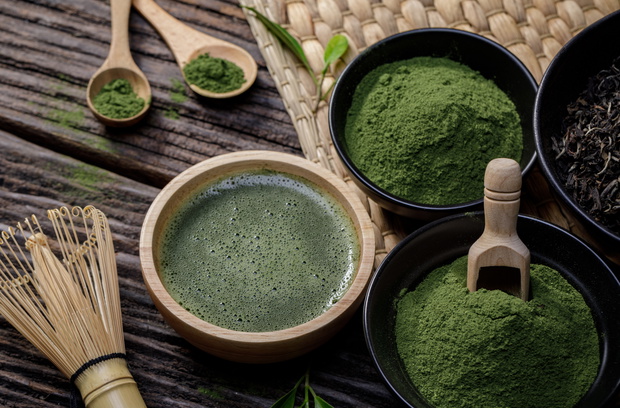 Japanese organic matcha green tea powder in bowl with wire whisk and green tea leaf on wooden background, Organic product from the nature for healthy with traditional style