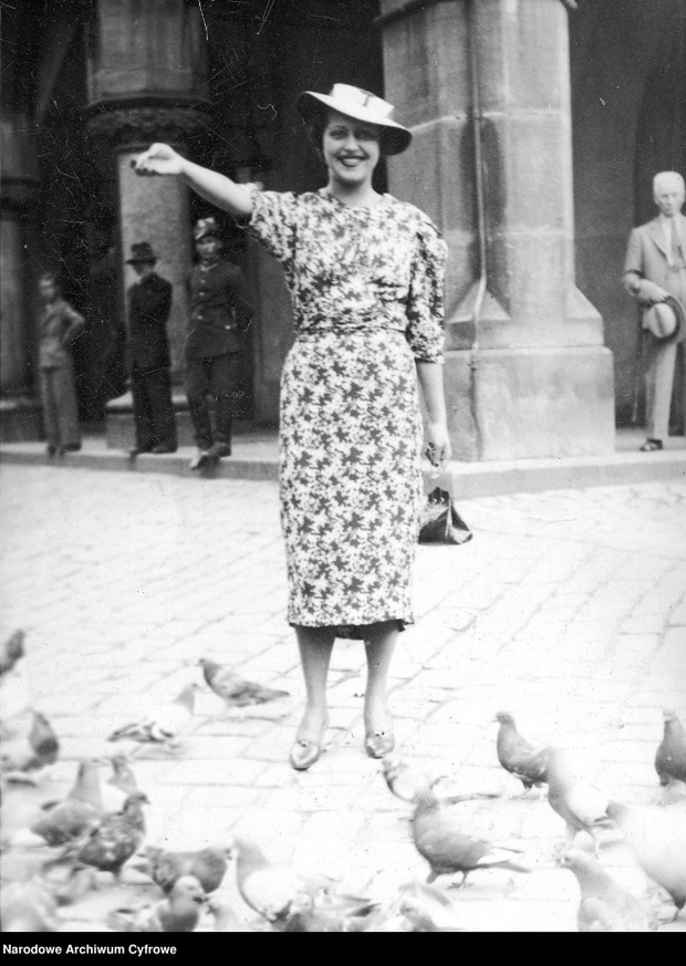 Elżbieta Kryńska, aktorka. Fotografia sytuacyjna (karmi gołębie przed Sukiennicami), 1937.