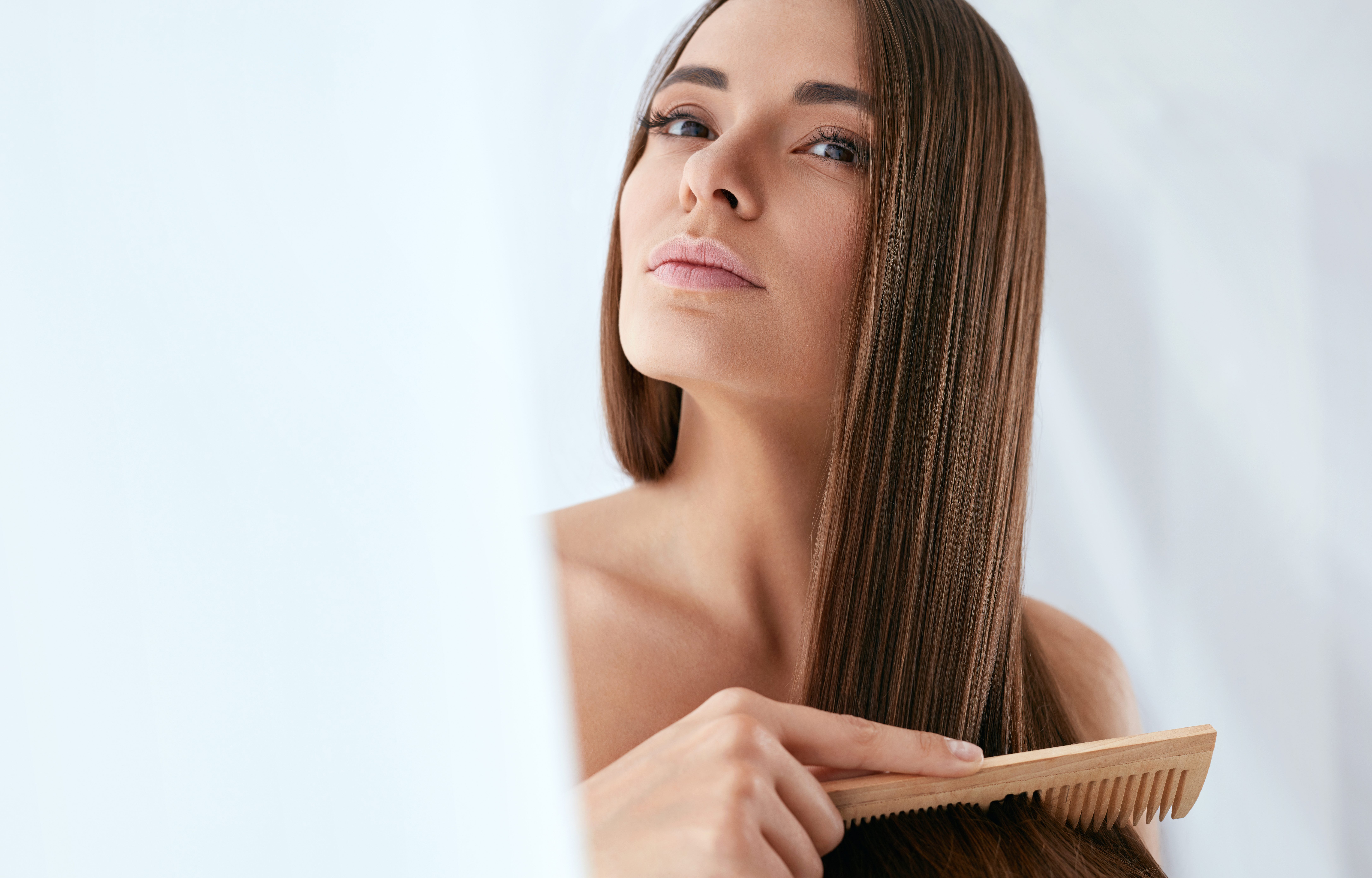 Beauty Hair Care. Beautiful Woman Combing Long Natural Hair
