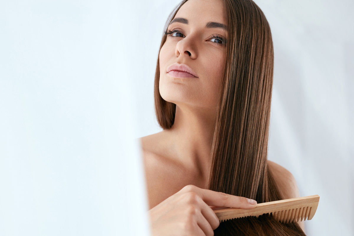 Beauty Hair Care. Beautiful Woman Combing Long Natural Hair