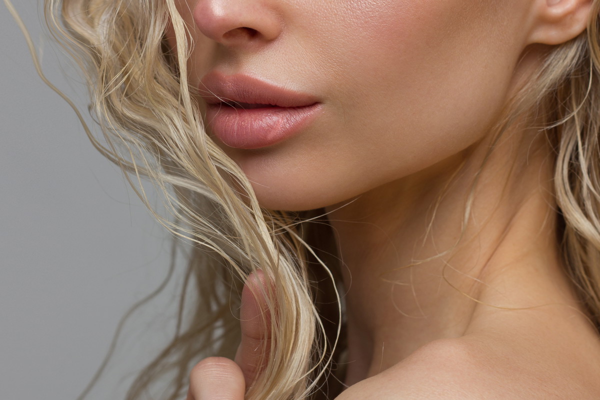 Close-up of woman's Lips with Fashion pink Make-up and Manicure on Nails. Beautiful female full lips with perfect Makeup. Part of female face. Macro shot of beautiful make up on full lips