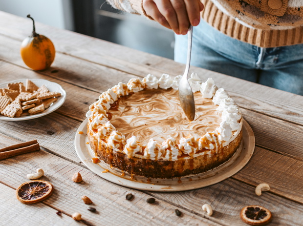 High angle shot of pumpkin cheesecake with caramel sauce on a table
