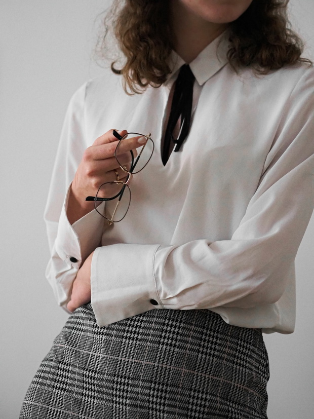 Vertical shot of a young woman's hands holding sunglasses and we
