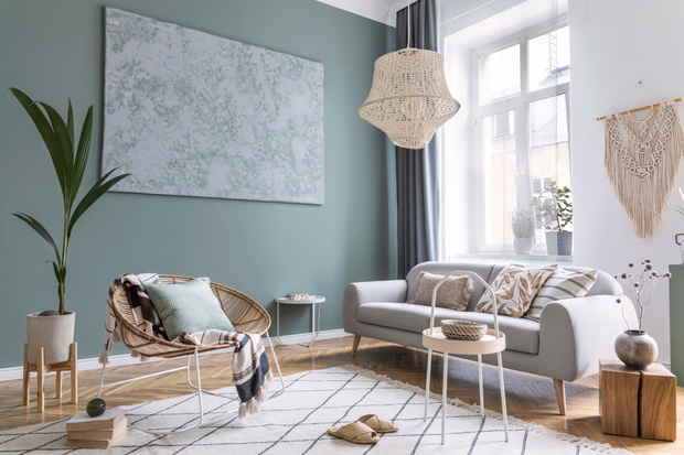 Boho interior design of living room with sofa and rattan armchai