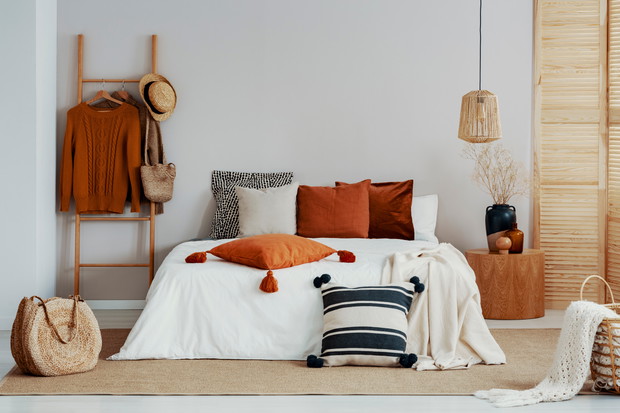 Copy space on white empty wall of trendy bedroom with flower in