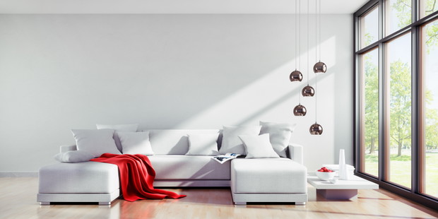 Sofa mit roter Decke in hellem sonnigem Raum