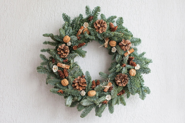 Christmas wreath made of natural fir branches hanging on a whit
