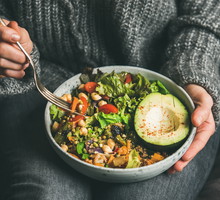 Woman eating healthy vegetarian dinner from Buddha bowl, close-up