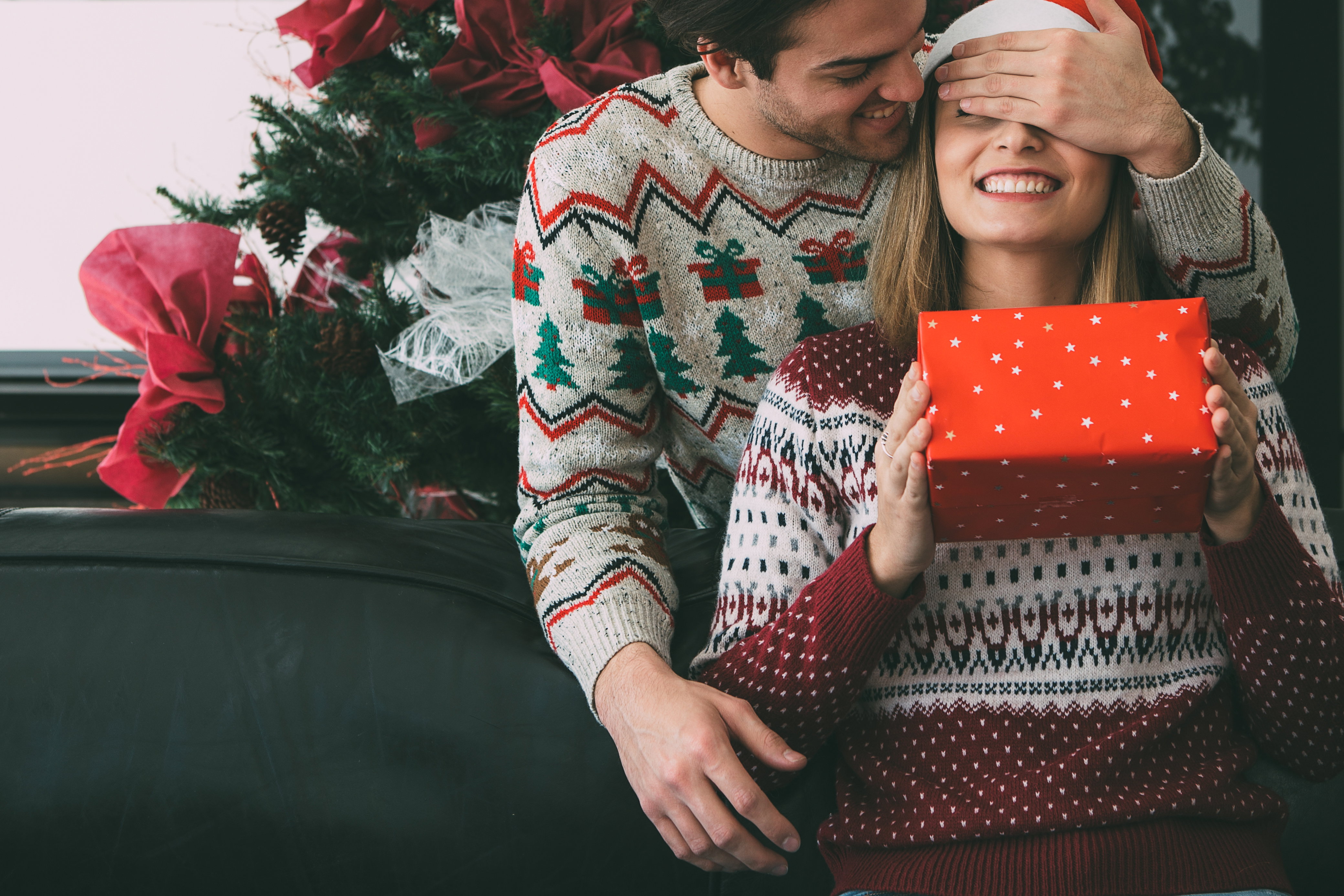 Young man surprise beloved woman with Christmas gift