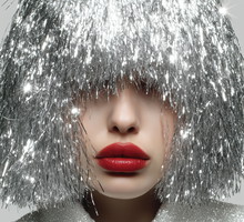 Festive Portrait of Woman with Red Lips and Silver Tinsel Hair on White Background