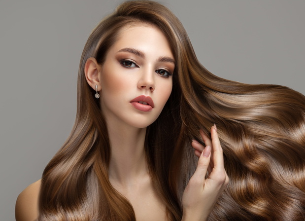 Portrait of a beautiful brunette woman with long wavy hair. Copy