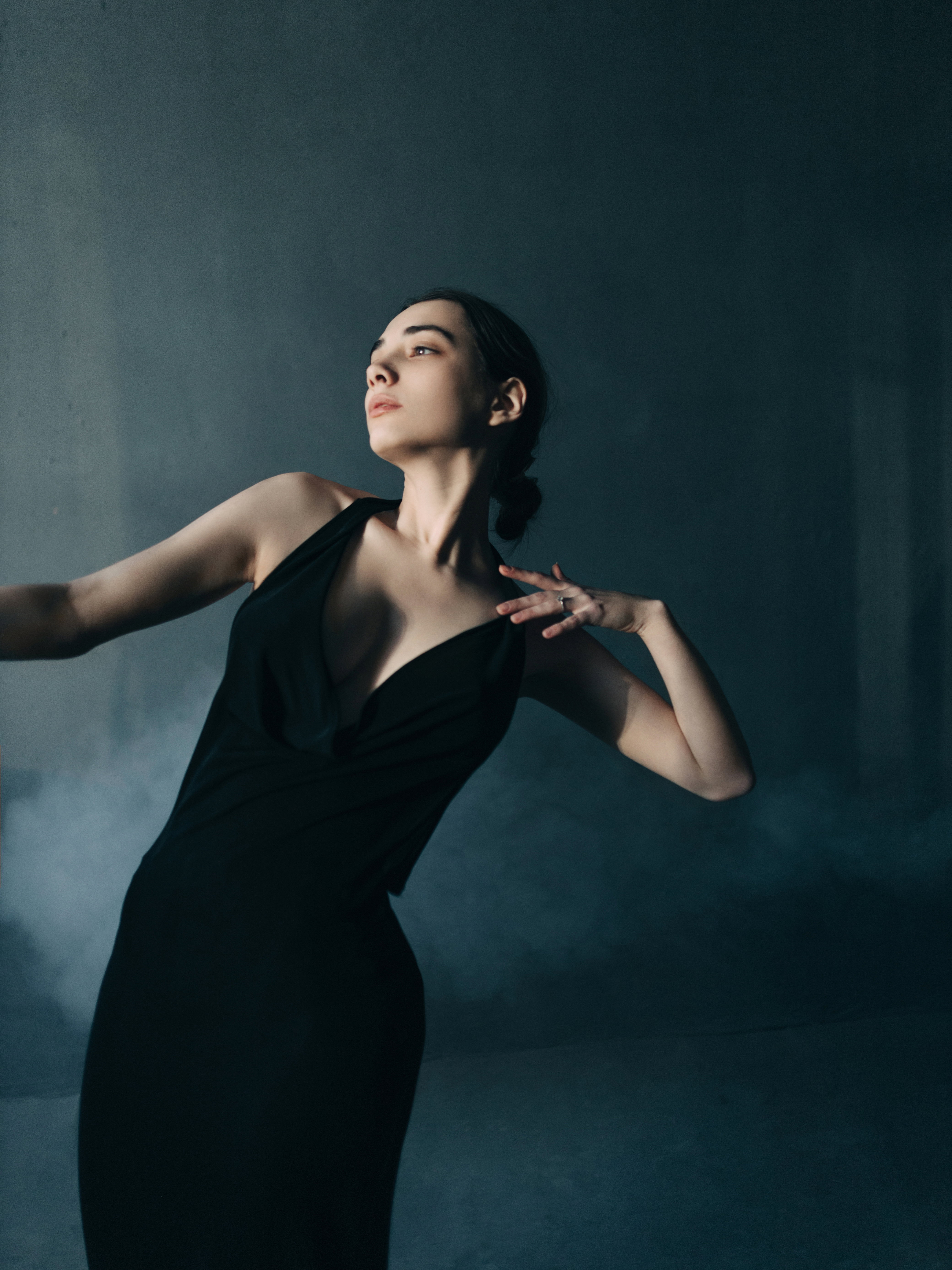 Young beautiful woman dancing in foggy room