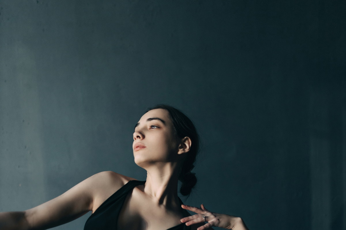 Young beautiful woman dancing in foggy room